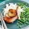 Pork cutlets with sliced red apple and maple syrup