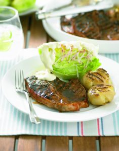 Barbecued lamb chops with potatoes and iceberg lettuce salad