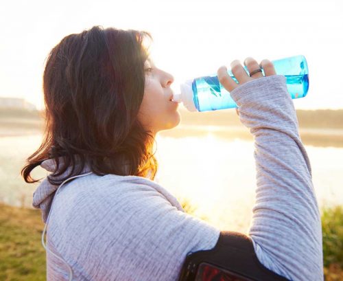 Woman drinking water after exercise