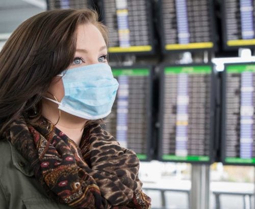 Woman with COVID-19 mask on at airport