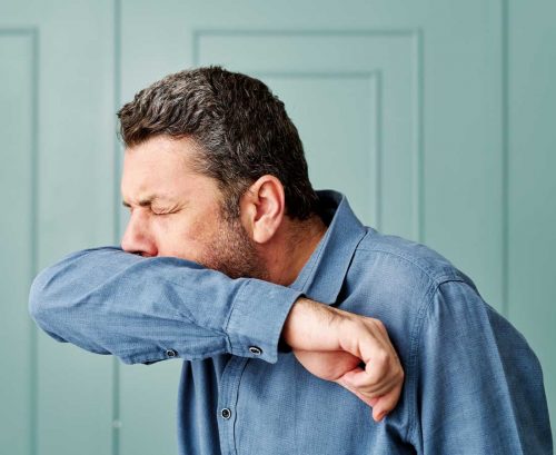 Man coughing into elbow