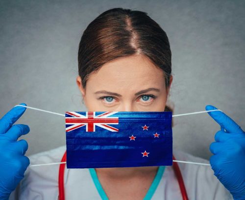 Doctor putting mask on with NZ flag on it