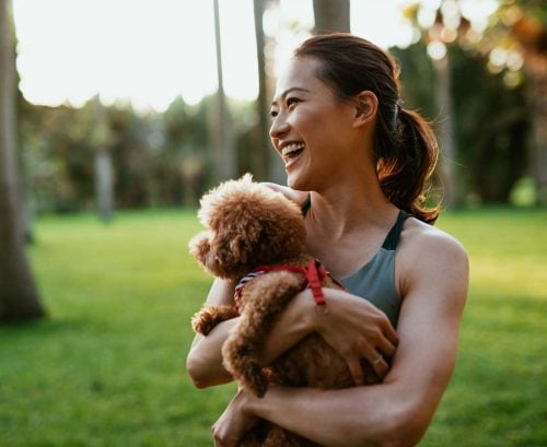 Healthy woman holding dog