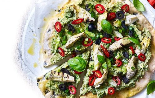 Vegan pizza with an olive crust and avocado and butter bean topping