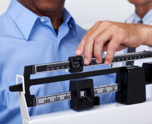 Man being weighed by doctor
