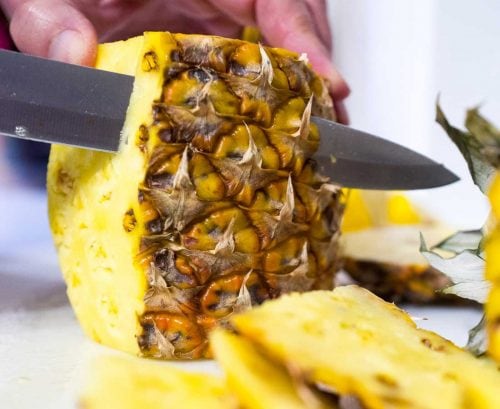 Person cutting up pineapple