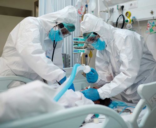 Medical staff in PPE intibating COVID patient