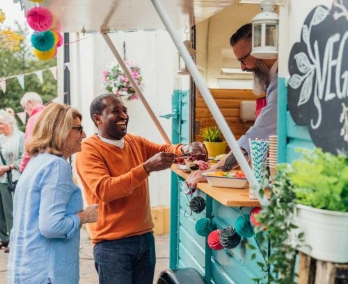 Older couple buying vegan food from a food truck