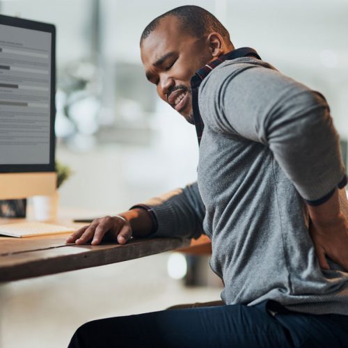 Man at his computer with back pain